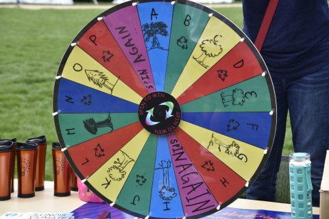 "Tree-via" wheel at the 2022 Arbor Day Celebration. The photo contains a colorful wheel with different tree related icons on the various sections of the wheel.