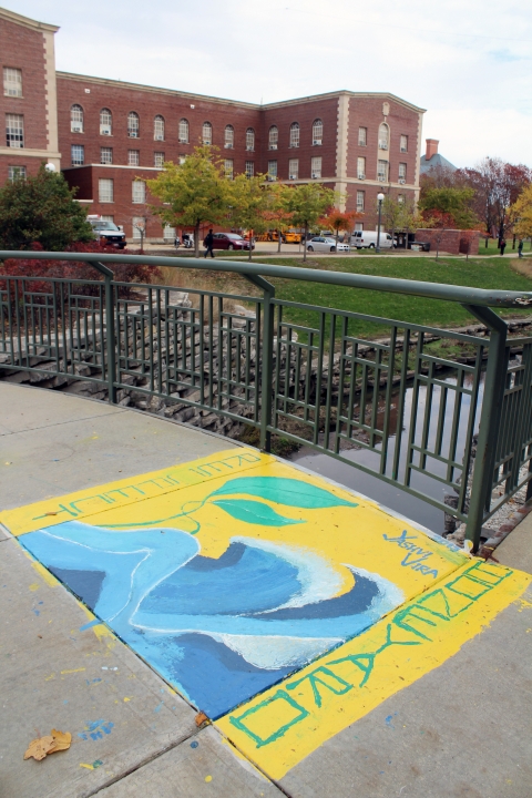 This picture shows the yellow mural is located on a bridge over Boneyard Creek near the Engineering Quad