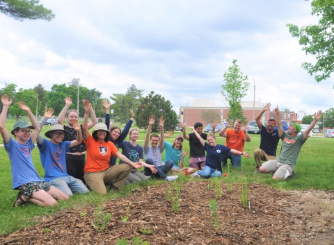 Group photo of the smiling volunteers after planting the pollinator garden.