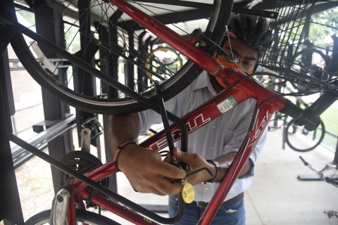 Sarthak Prasad locking his bicycle to the Bike Shelter