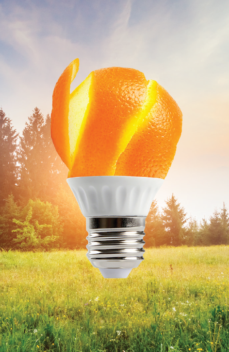 A light bulb where the bulb is a semi-sliced orange with a bright orange light shining from it. 